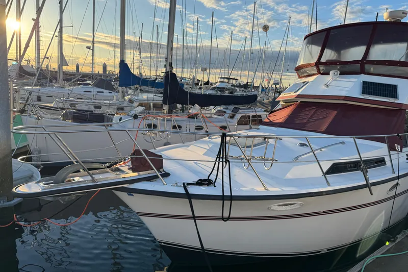 Slide: The Image of 1987 President 37 yacht docked at marina during sunset, surrounded by sailboats. - 3