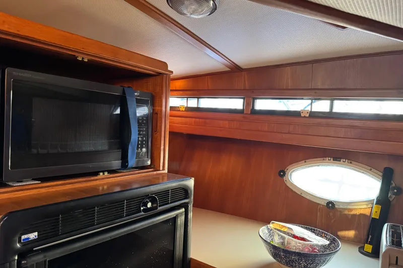 Slide: The Image of 1987 President 37 yacht kitchen with microwave, oven, and porthole window. - 31