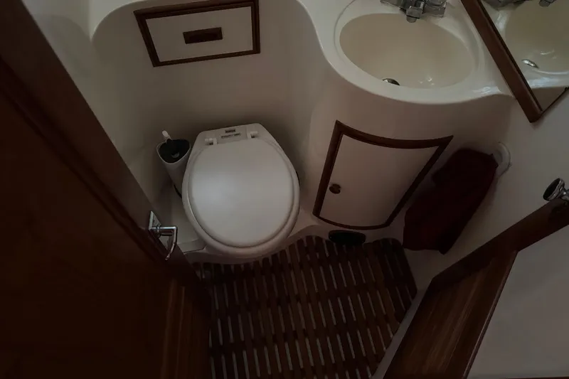 Slide: The Image of Compact bathroom in a 1987 President 37 yacht, featuring a toilet and sink. - 38