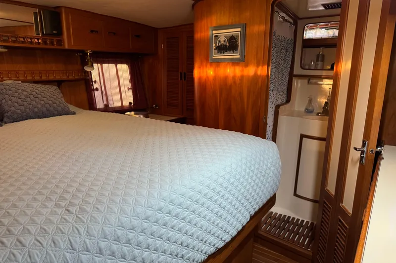 Slide: The Image of Cozy bedroom in 1987 President 37 yacht with wood paneling and ensuite bathroom. - 47
