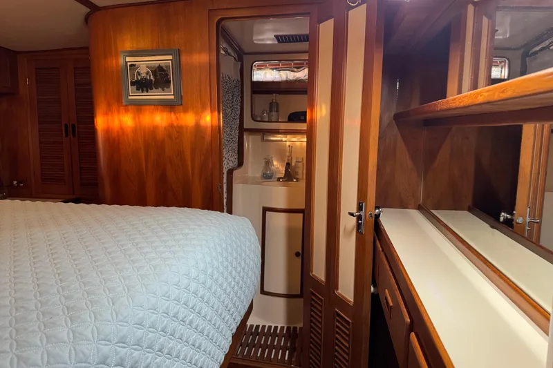Slide: The Image of Cozy 1987 President 37 yacht cabin with wood paneling and a neatly made bed. - 48