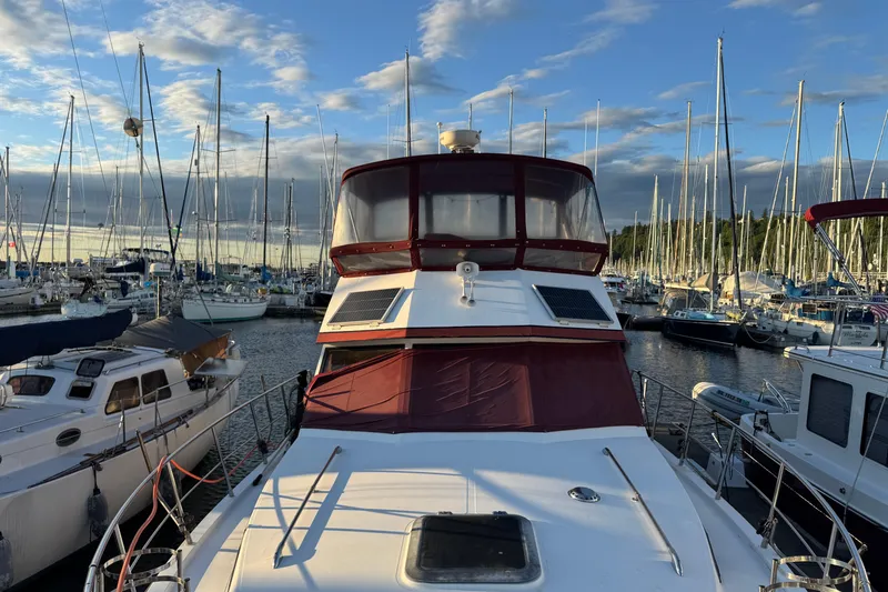 Slide: The Image of 1987 President 37 yacht docked in a marina, surrounded by sailboats under a blue sky. - 5
