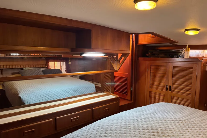 Slide: The Image of Luxurious 1987 President 37 yacht bedroom with wooden cabinetry and cozy bedding. - 51