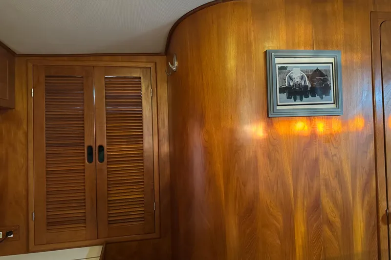 Slide: The Image of Wood-paneled interior of a 1987 President 37 yacht with framed artwork and louvered cabinet doors. - 52