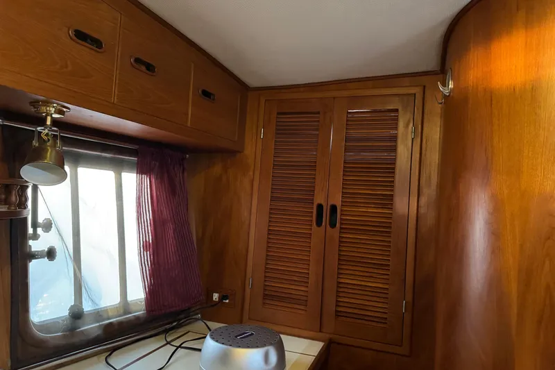 Slide: The Image of Wood-paneled interior of a 1987 President 37 boat with window and storage cabinets. - 53