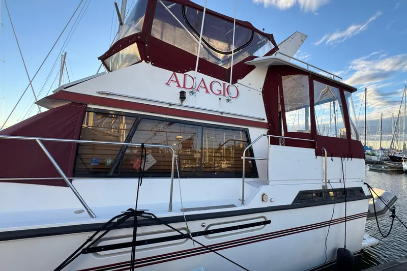 Slide: The Image of 1987 President 37 yacht "Adagio" docked at marina with red accents and clear skies. - 6