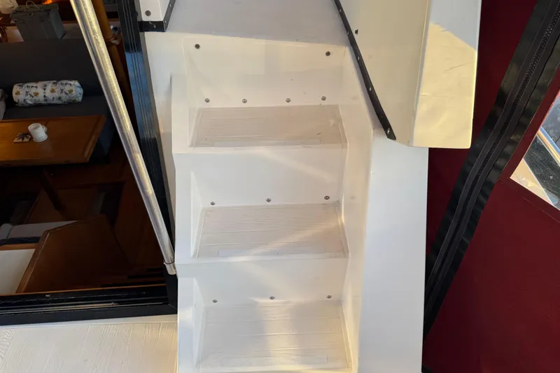 Slide: The Image of White stairs inside a 1987 President 37 yacht, with a cozy interior view. - 61