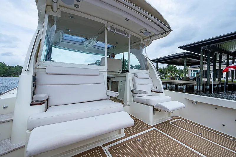 Slide: The Image of 2023 Hinckley Sport Boat 40 X interior with white seating and wooden deck. - 9