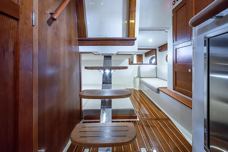 Slide: The Image of Interior of 2023 Hinckley Sport Boat 40 X with wooden stairs and seating area. - 19