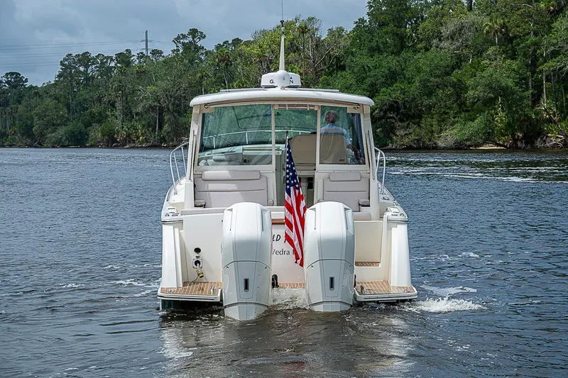 Slide: The Image of 2023 Hinckley Sport Boat 40 X cruising on a scenic river with lush greenery. - 4