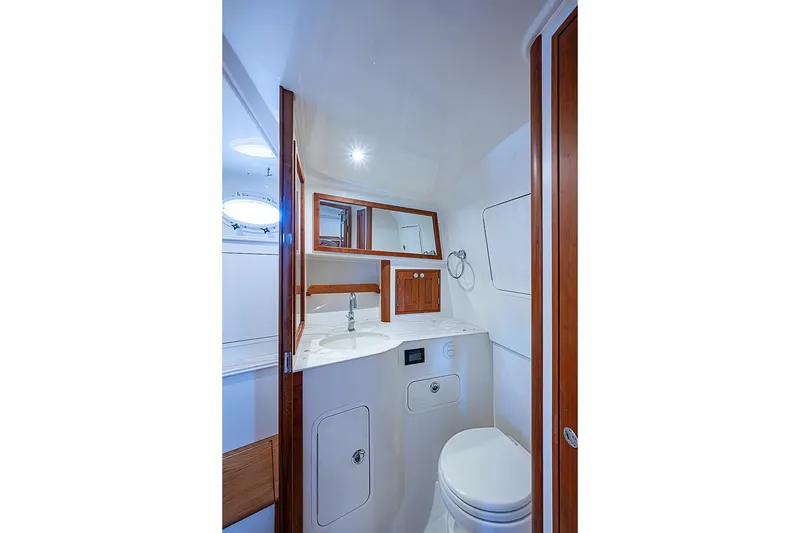 Slide: The Image of Luxurious bathroom interior of 2023 Hinckley Sport Boat 40 X, featuring modern fixtures and wood accents. - 25