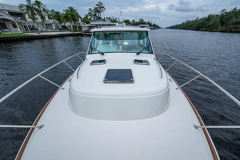 Slide: The Image of 2023 Hinckley Sport Boat 40 X cruising on a scenic river with lush surroundings. - 18