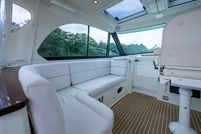 Slide: The Image of Interior of 2023 Hinckley Sport Boat 40 X with white seating and wood flooring. - 14