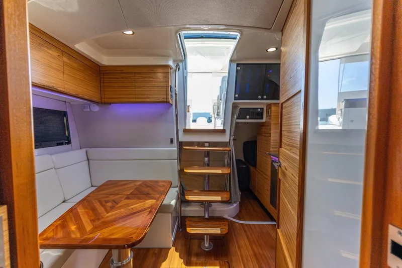 Slide: The Image of Interior of 2023 Boston Whaler 405 Conquest, featuring wooden accents and modern seating area. - 10