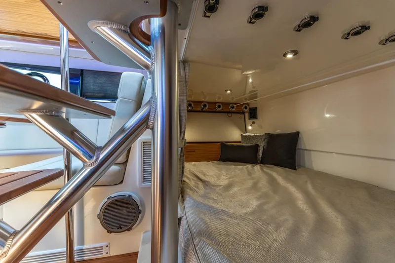 Slide: The Image of 2023 Boston Whaler 405 Conquest cabin interior with bed and modern design elements. - 15
