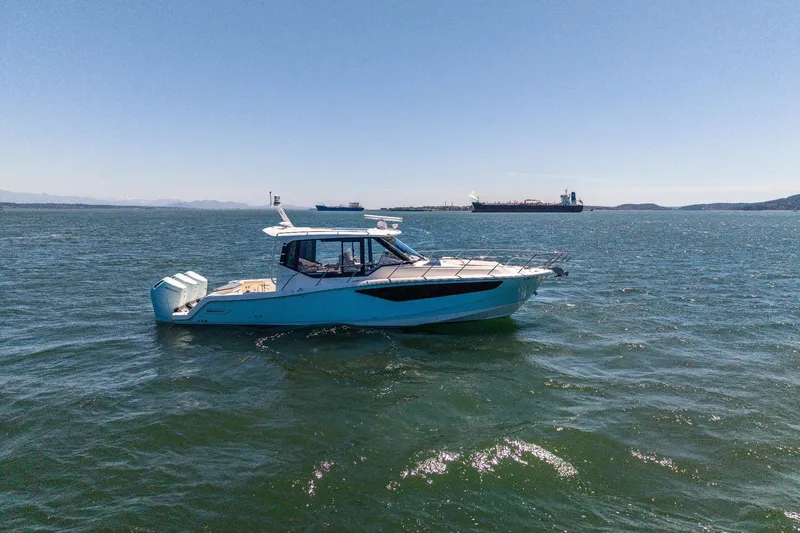 Slide: The Image of 2023 Boston Whaler 405 Conquest boat on open water, clear sky background. - 2