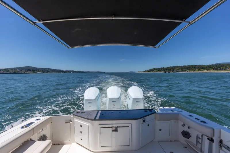 Slide: The Image of Boston Whaler 405 Conquest 2023 cruising on open water under a clear blue sky. - 20
