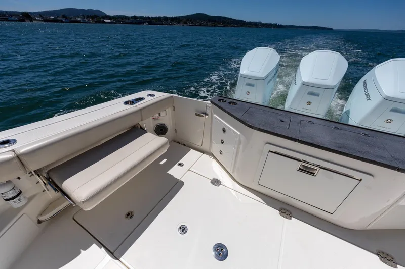 Slide: The Image of 2023 Boston Whaler 405 Conquest boat deck with seating and triple Mercury engines. - 21