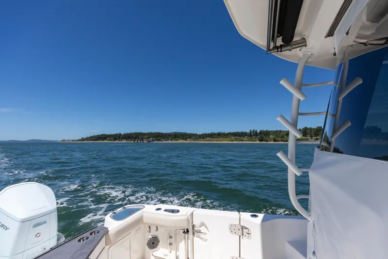 Slide: The Image of 2023 Boston Whaler 405 Conquest cruising on open water under clear blue skies. - 26