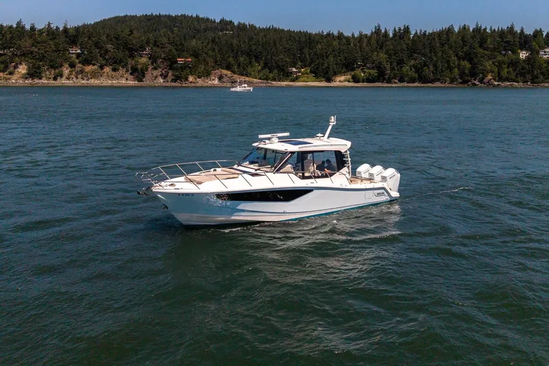 Slide: The Image of 2023 Boston Whaler 405 Conquest cruising on a scenic lake with forested shoreline. - 3