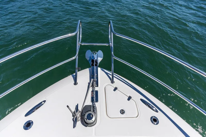 Slide: The Image of Bow of 2023 Boston Whaler 405 Conquest, featuring anchor and railing over water. - 34