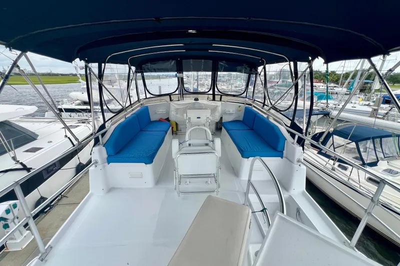Slide: The Image of 1999 Mainship 350 Trawler interior with blue seating, docked at marina. - 18