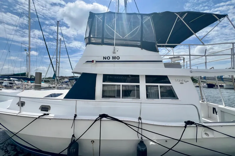 Slide: The Image of 1999 Mainship 350 Trawler docked at marina under blue sky. - 2