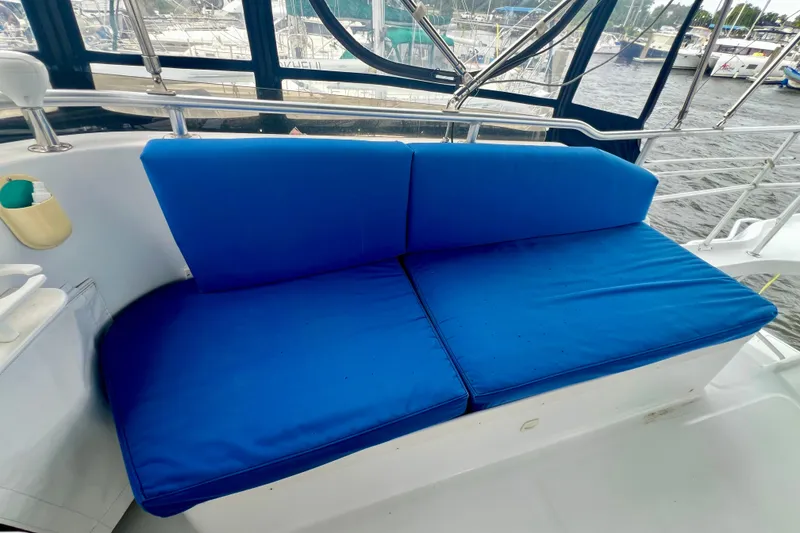 Slide: The Image of Blue cushioned seating on 1999 Mainship 350 Trawler, docked with marina view. - 22