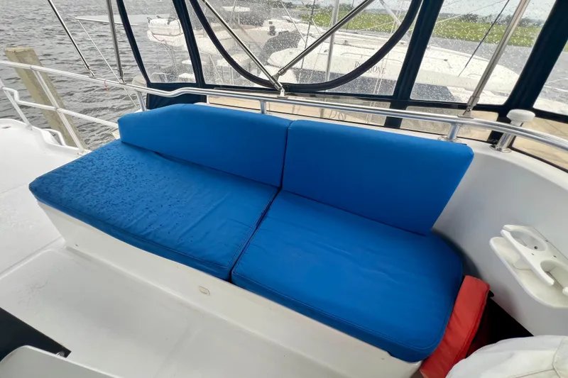Slide: The Image of Blue cushioned seating on 1999 Mainship 350 Trawler boat deck, near water. - 23