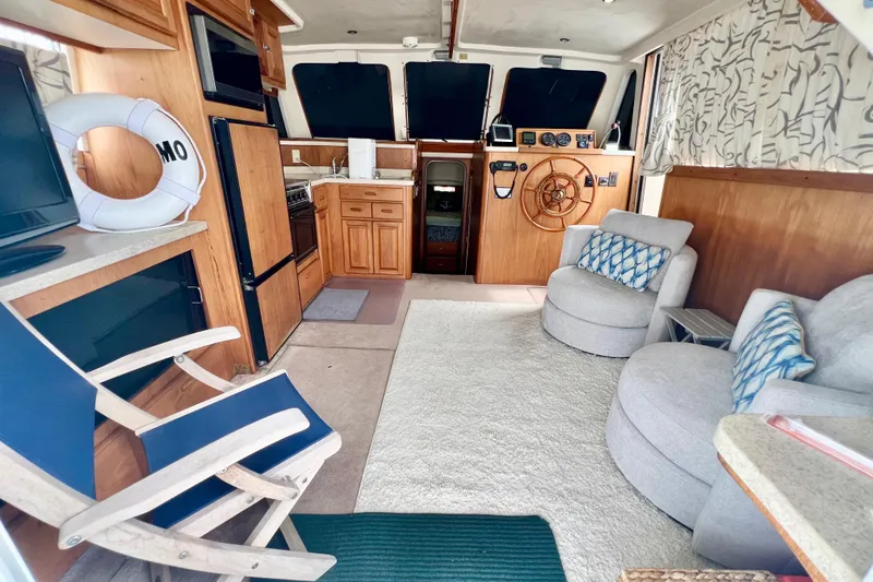 Slide: The Image of Interior of 1999 Mainship 350 Trawler with cozy seating, helm, and kitchenette. - 26