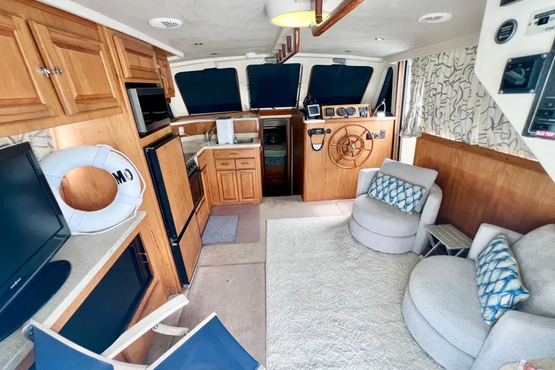 Slide: The Image of Interior of a 1999 Mainship 350 Trawler with cozy seating and wooden cabinetry. - 27