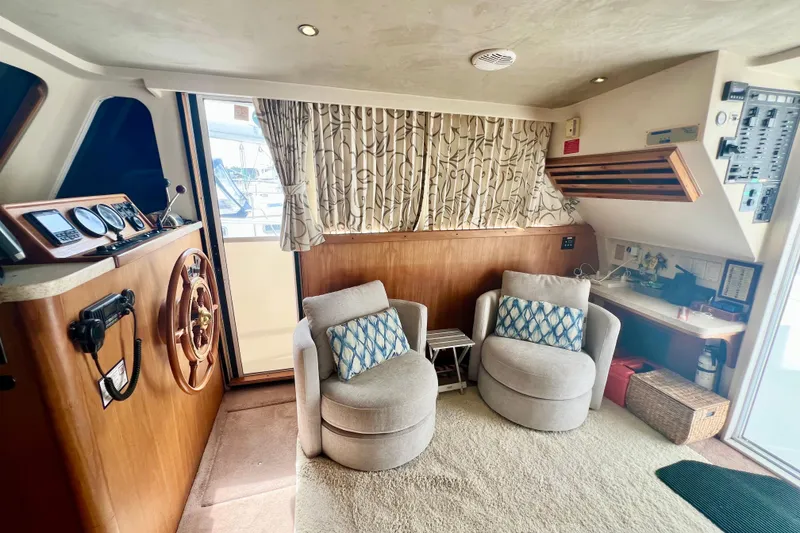 Slide: The Image of Interior of 1999 Mainship 350 Trawler with helm, seating, and nautical decor. - 28