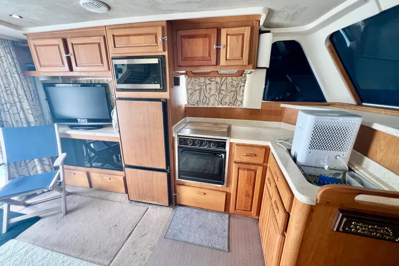 Slide: The Image of Interior of 1999 Mainship 350 Trawler with kitchen, wooden cabinets, and appliances. - 29