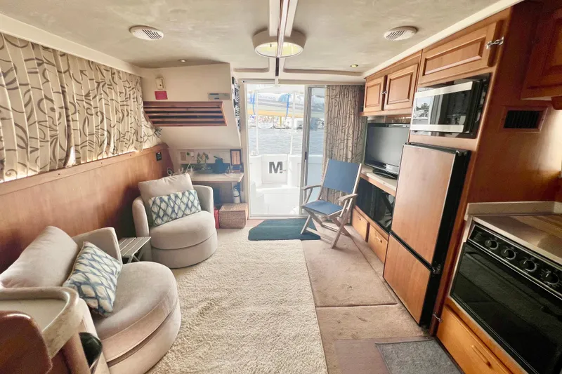 Slide: The Image of Interior of 1999 Mainship 350 Trawler with cozy seating, kitchen, and entertainment area. - 30