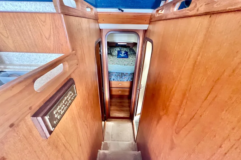 Slide: The Image of 1999 Mainship 350 Trawler interior with wooden stairs leading to cozy cabin. - 33