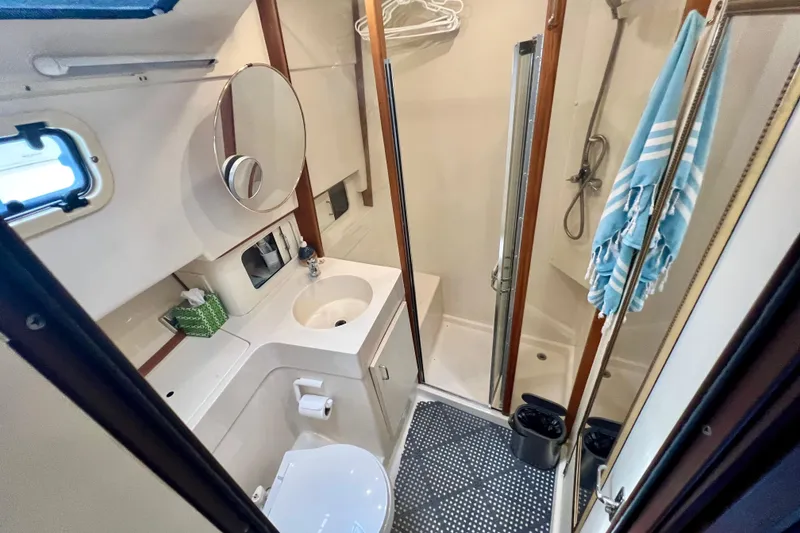 Slide: The Image of Bathroom interior of 1999 Mainship 350 Trawler with shower, sink, and toilet. - 34