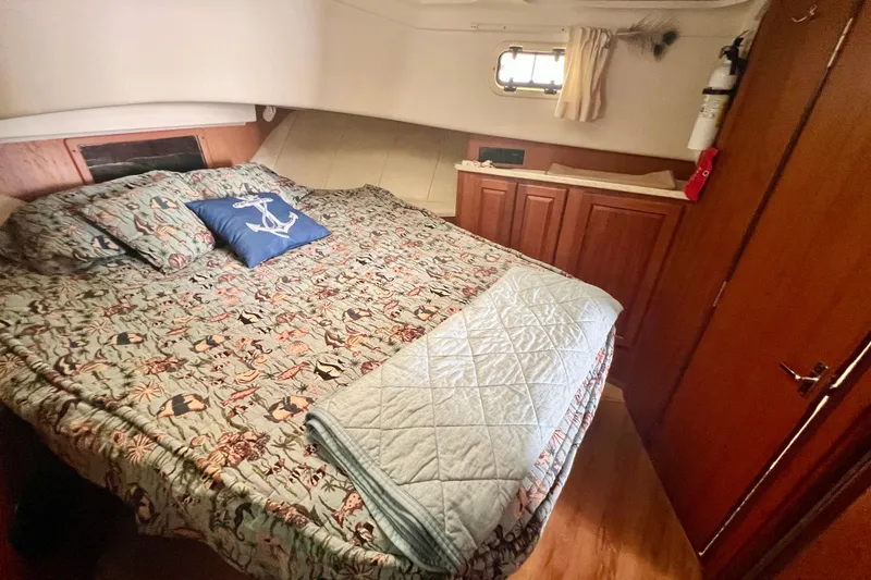 Slide: The Image of Cozy bedroom in 1999 Mainship 350 Trawler with nautical-themed bedding and wooden cabinetry. - 37
