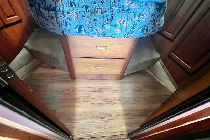 Slide: The Image of Interior cabin of 1999 Mainship 350 Trawler with wooden flooring and storage drawers. - 38