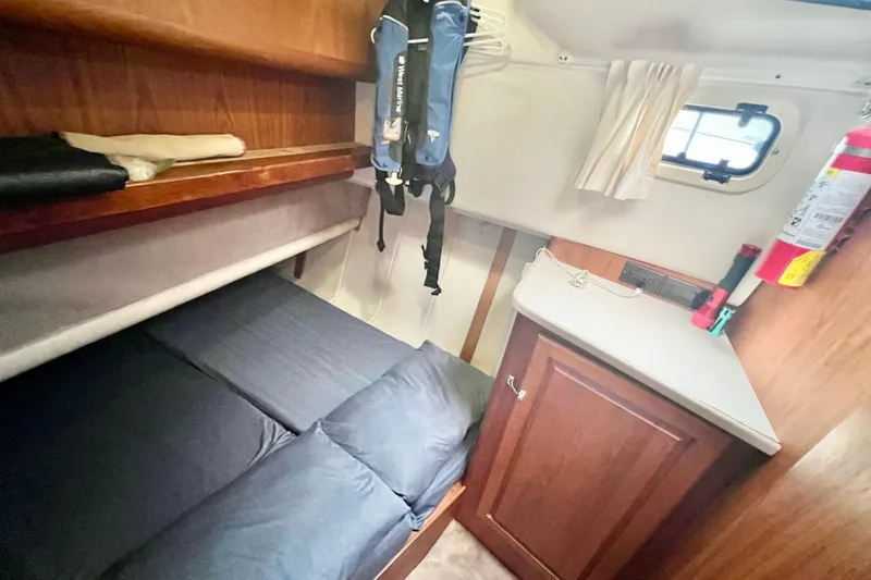 Slide: The Image of Cozy cabin interior of 1999 Mainship 350 Trawler with bunk bed and storage. - 39