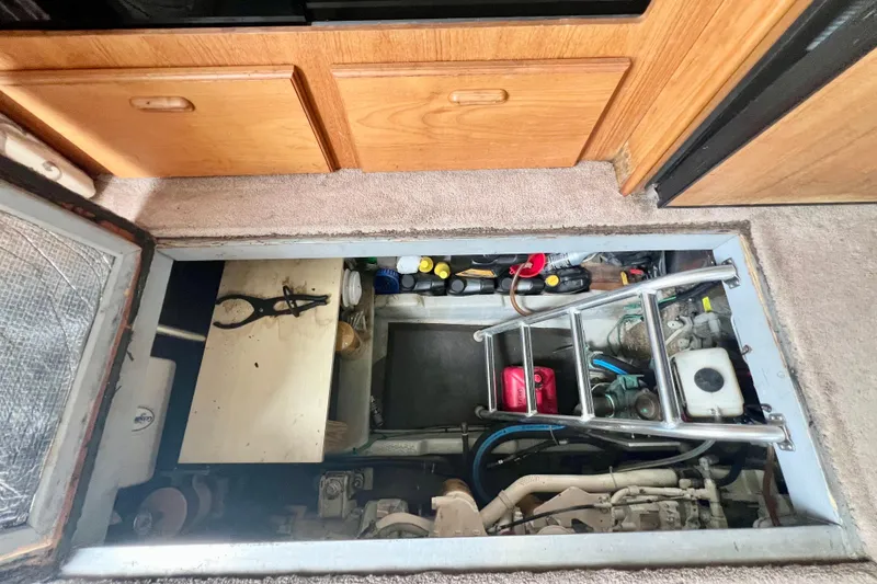 Slide: The Image of Engine compartment of a 1999 Mainship 350 Trawler with tools and equipment visible. - 41