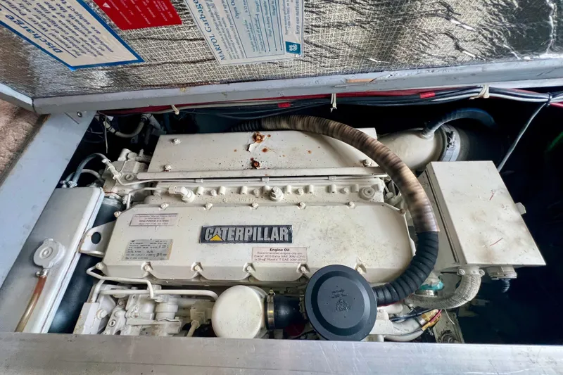 Slide: The Image of Engine compartment of a 1999 Mainship 350 Trawler featuring a Caterpillar engine. - 42