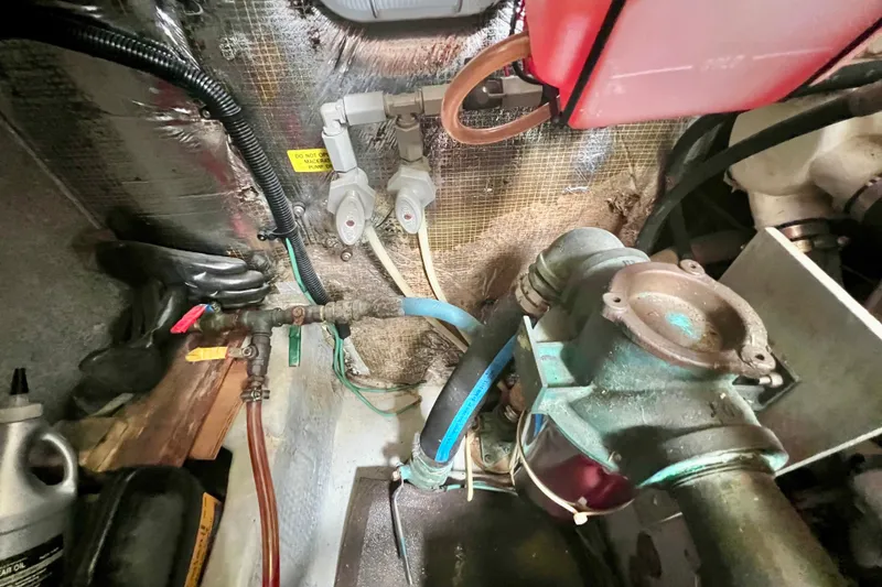 Slide: The Image of Engine room of a 1999 Mainship 350 Trawler, showcasing mechanical components and wiring. - 46