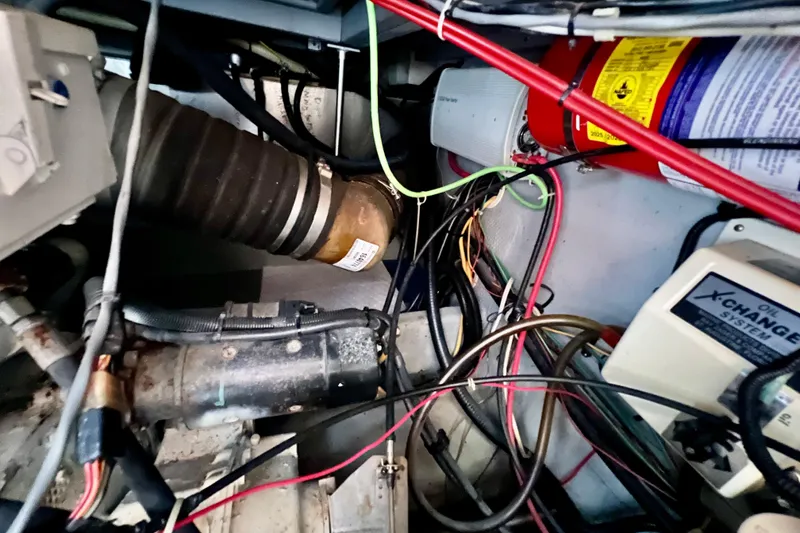 Slide: The Image of Engine compartment of a 1999 Mainship 350 Trawler with wiring and components visible. - 50