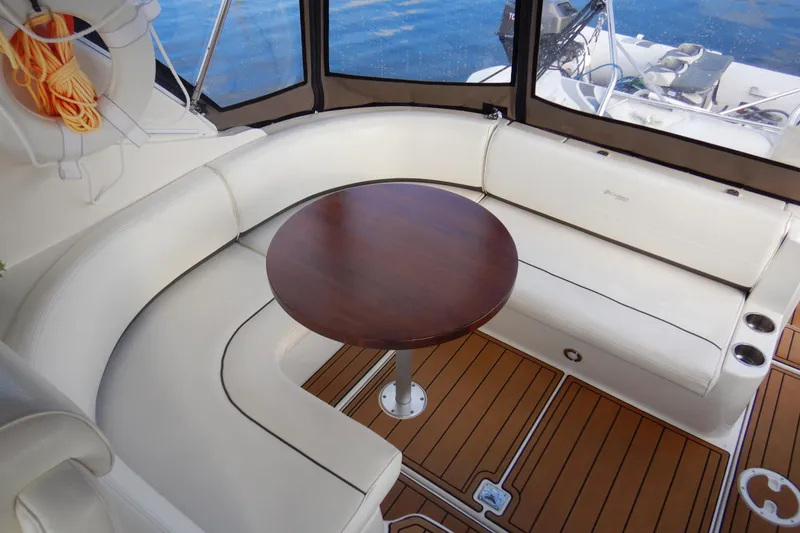 Slide: The Image of 2007 Cruisers 340 Express yacht interior with white seating and wooden table. - 16