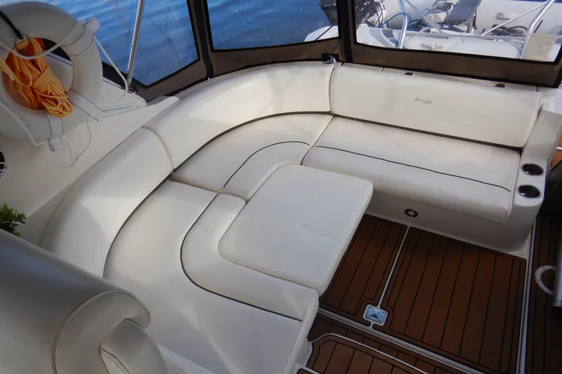 Slide: The Image of 2007 Cruisers 340 Express boat interior with white seating and wooden flooring. - 18