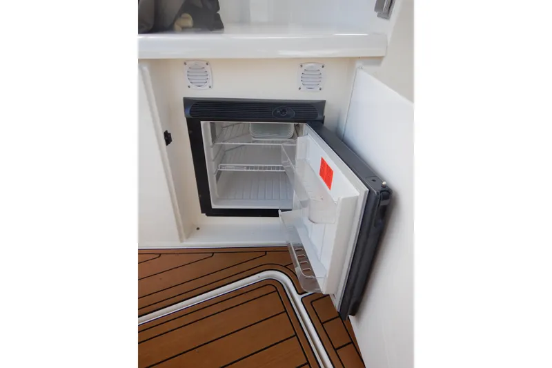 Slide: The Image of Open mini fridge on 2007 Cruisers 340 Express boat with teak flooring. - 20