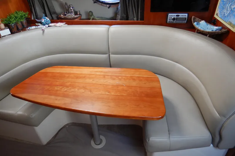 Slide: The Image of 2007 Cruisers 340 Express yacht interior with curved seating and wooden table. - 24