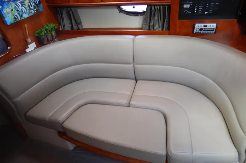 Slide: The Image of 2007 Cruisers 340 Express yacht interior with curved beige seating and wooden accents. - 25