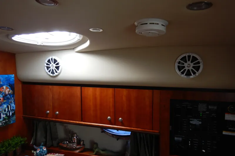 Slide: The Image of 2007 Cruisers 340 Express cabin interior with wood cabinets and ceiling speakers. - 26