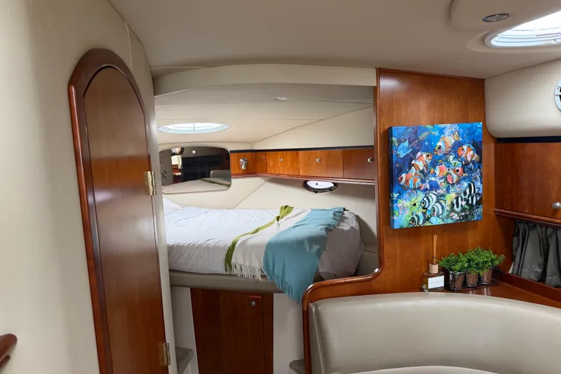 Slide: The Image of Luxurious 2007 Cruisers 340 Express cabin interior with bed, artwork, and wooden accents. - 27